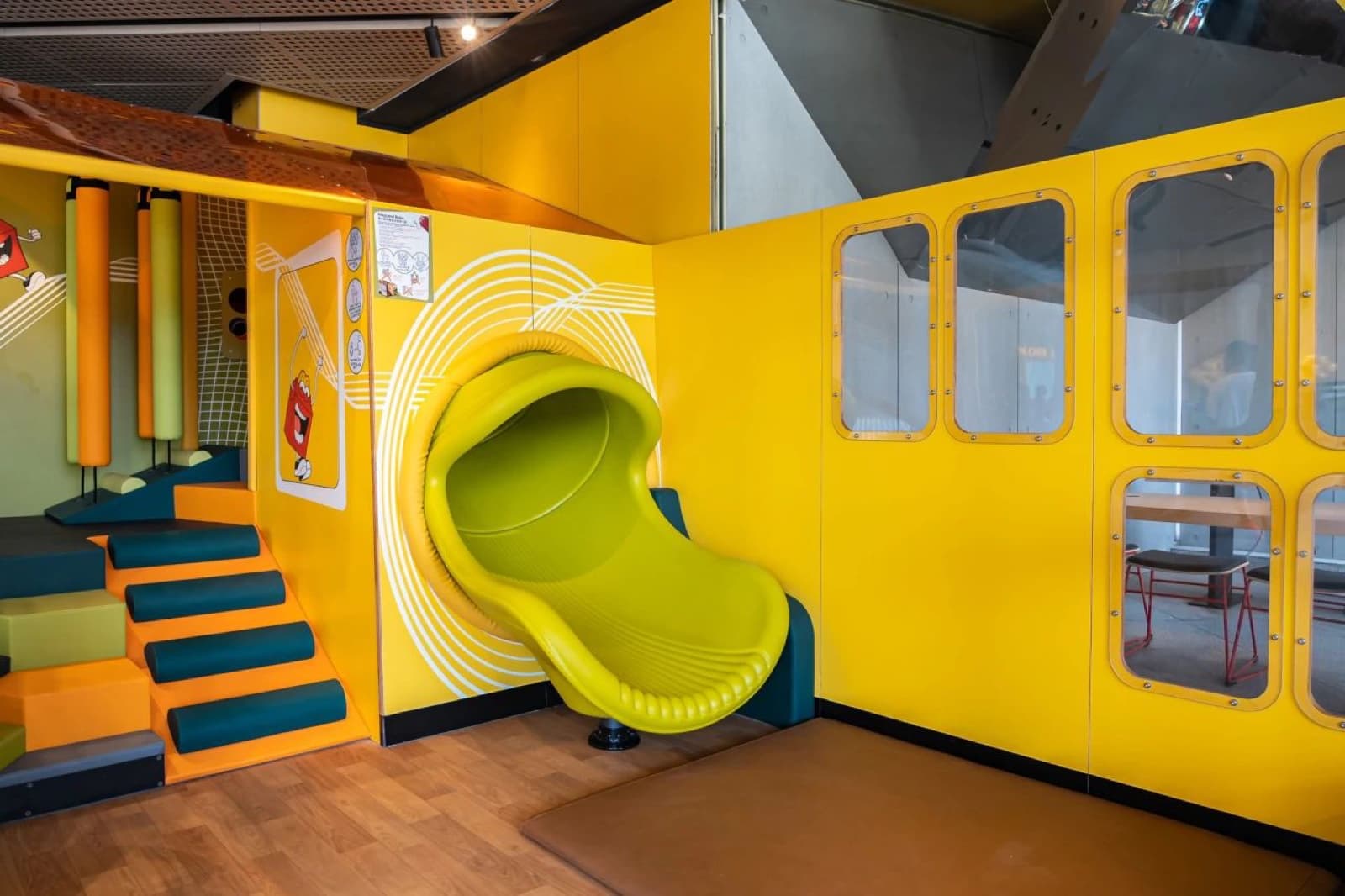 Wood-grain PVC flooring combined with red EUROFLEX impact-protection safety mat under play structure