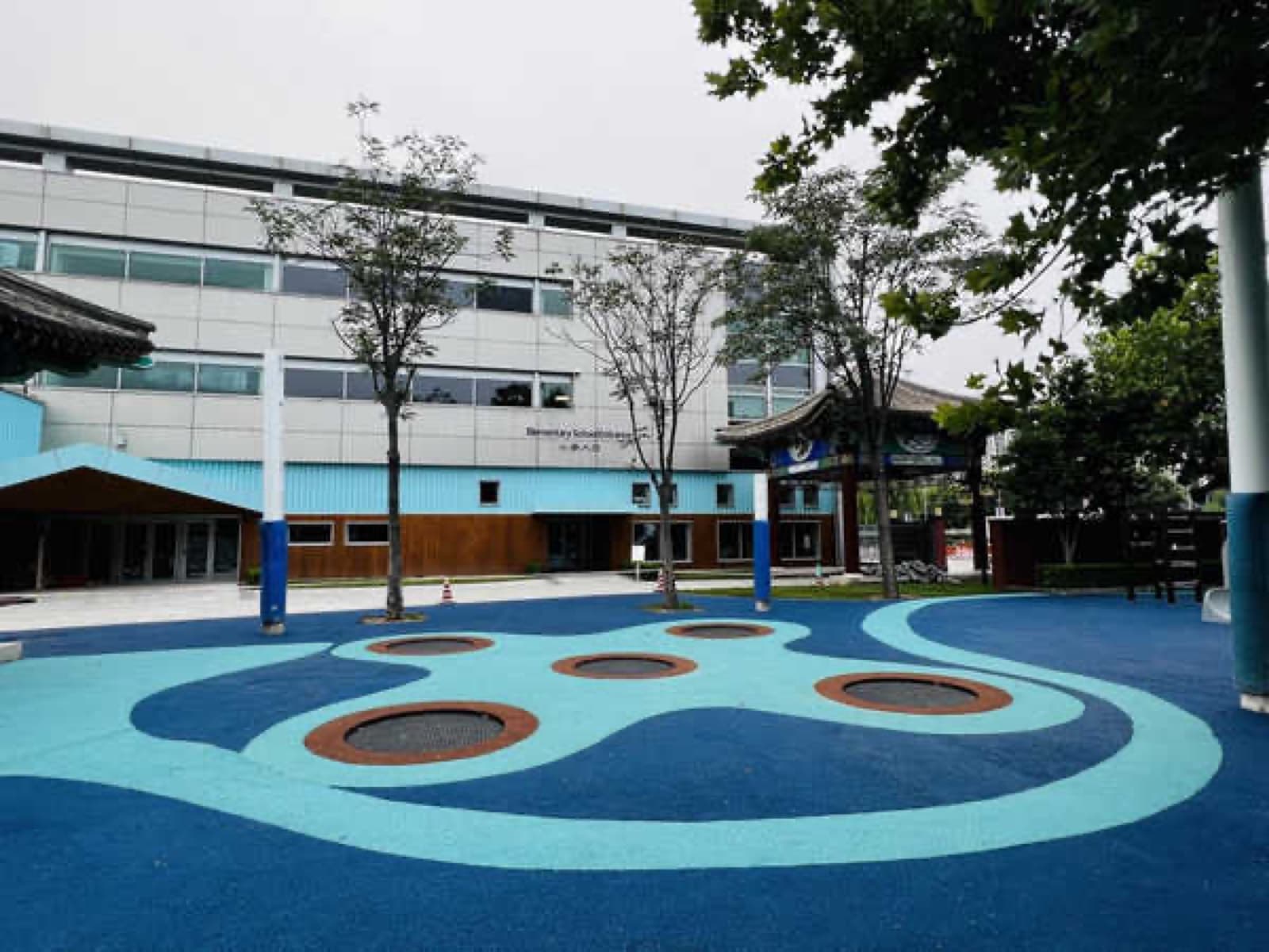Blue EPDM playground with circular patterns at the international school