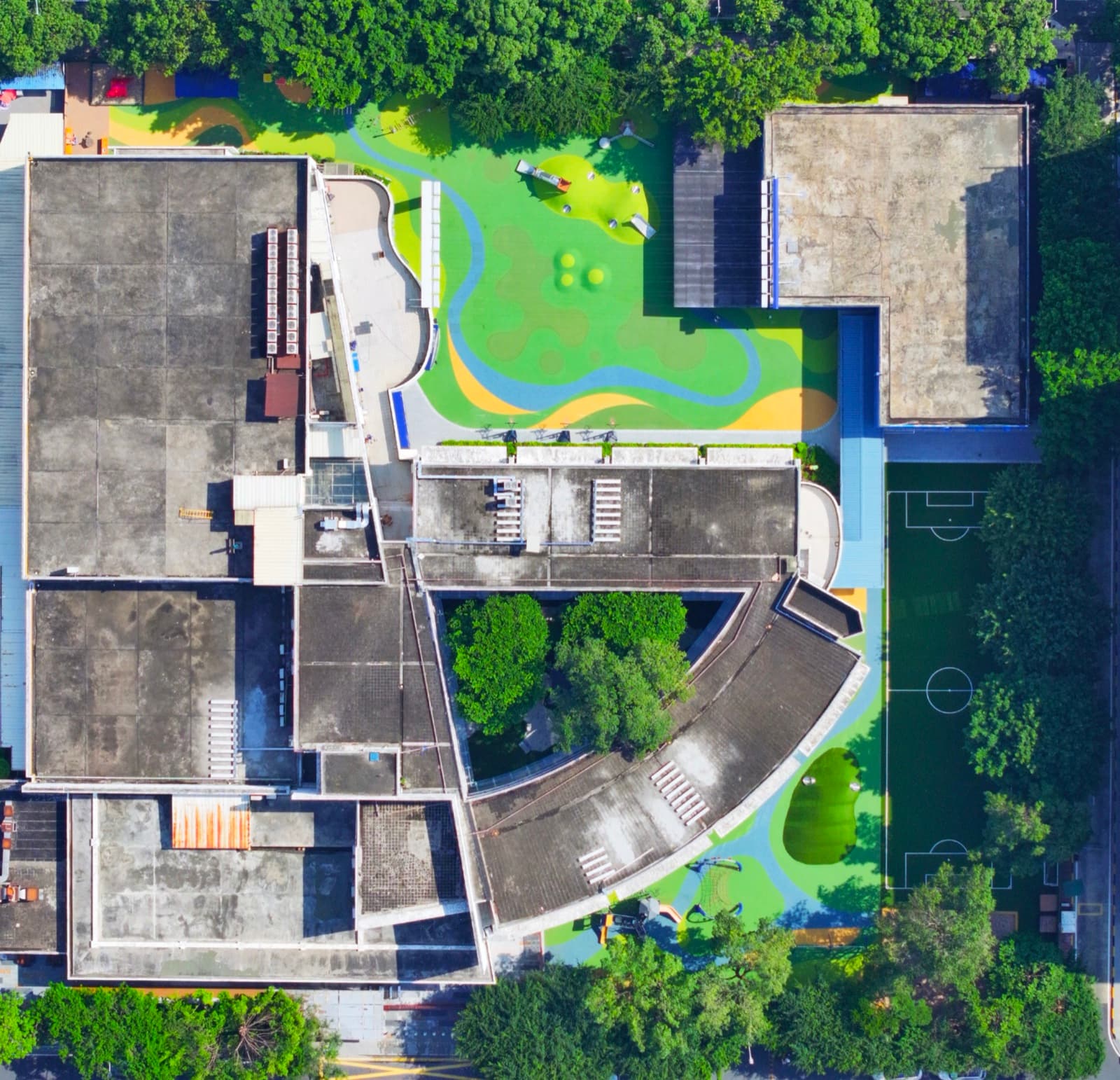 Full campus aerial showing the EPDM playground patterns