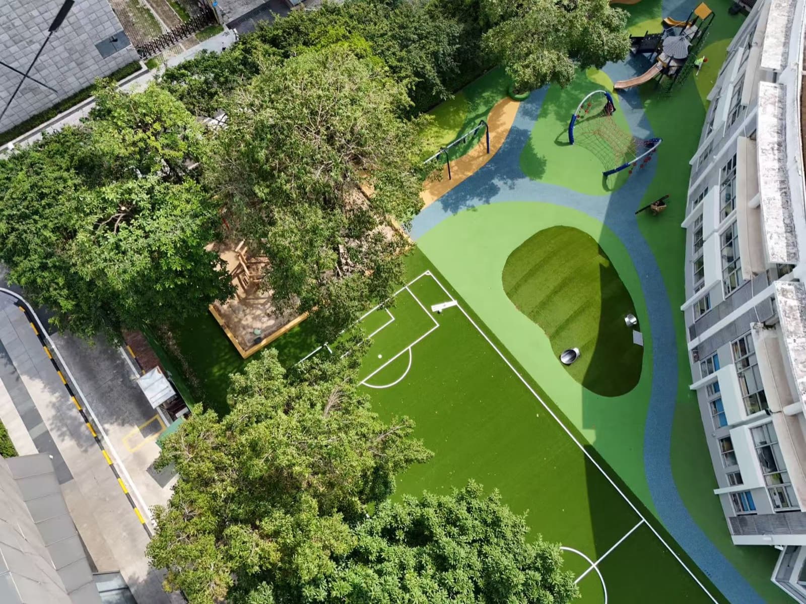 Aerial view of the custom EPDM play zone with blue curves and green surfacing